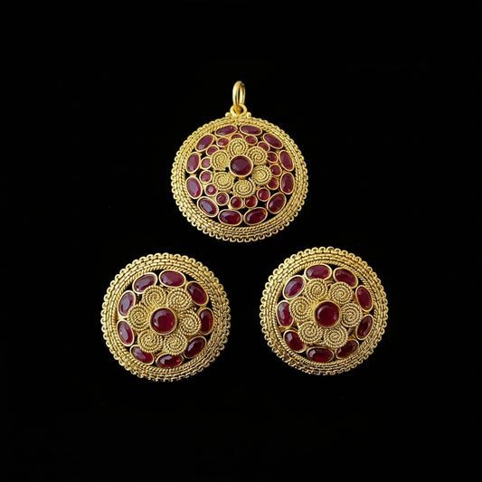 Gold and red gemstone earrings on a dark background with 'SAHELLI' branding.