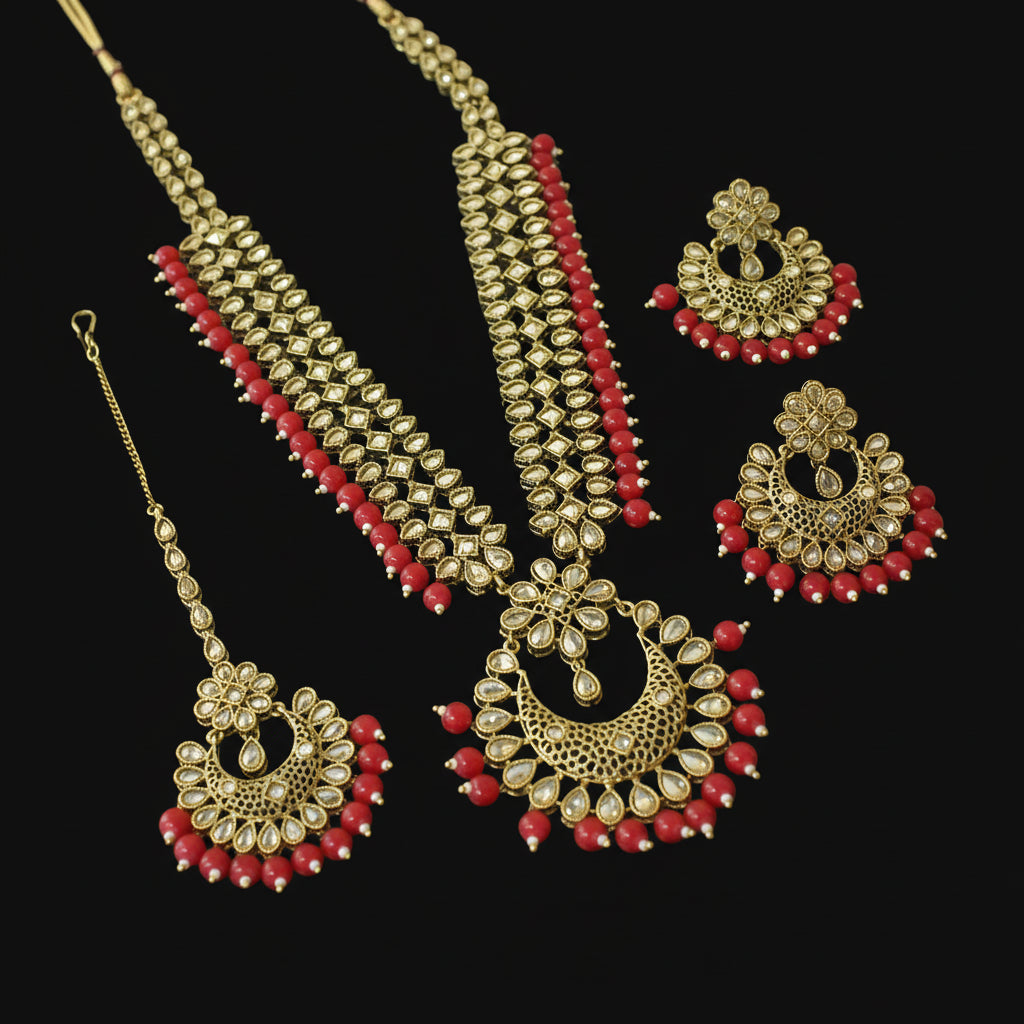 Gold and red jewelry set including necklace, earrings, and hair accessories on a dark background