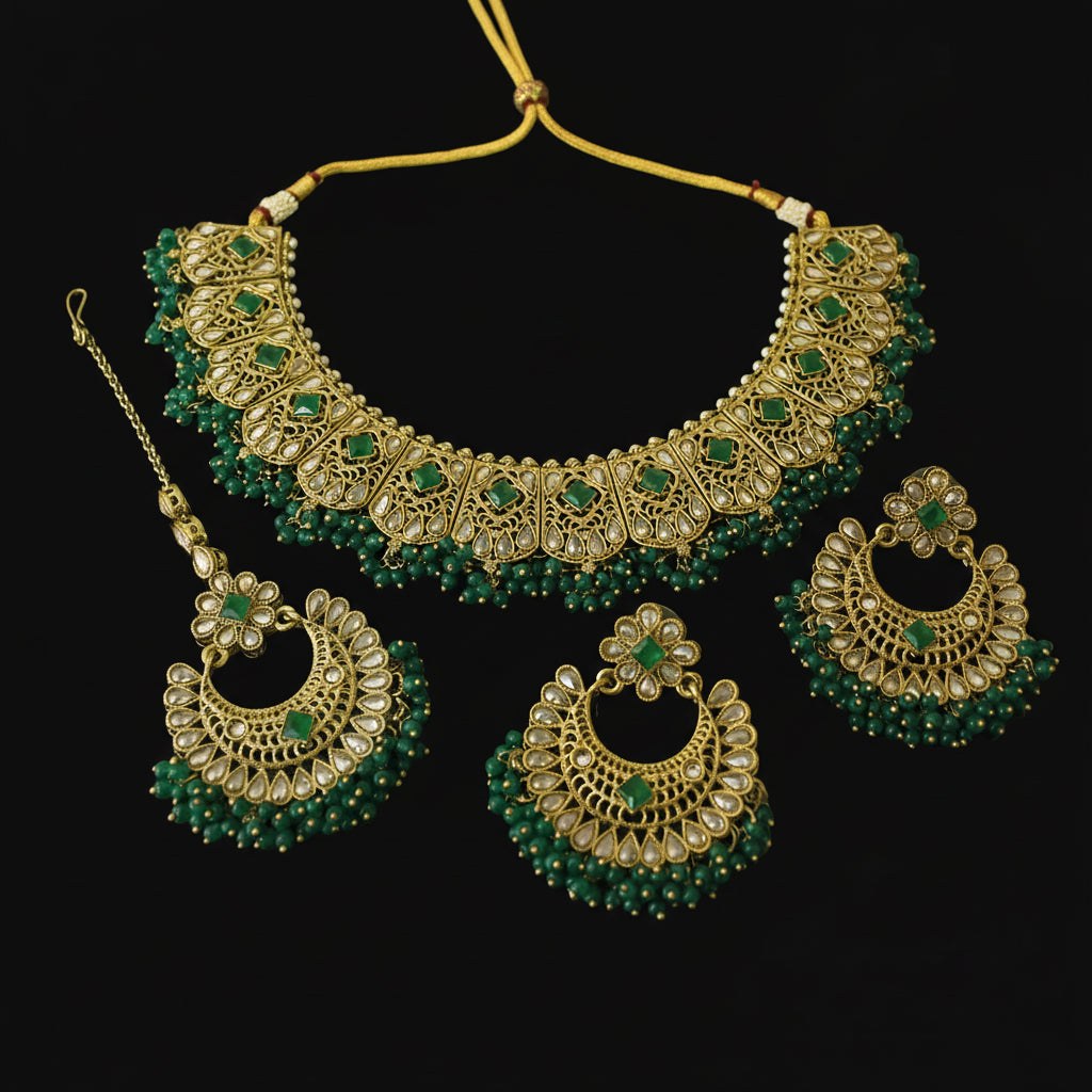 Gold and green jewelry set on a dark background