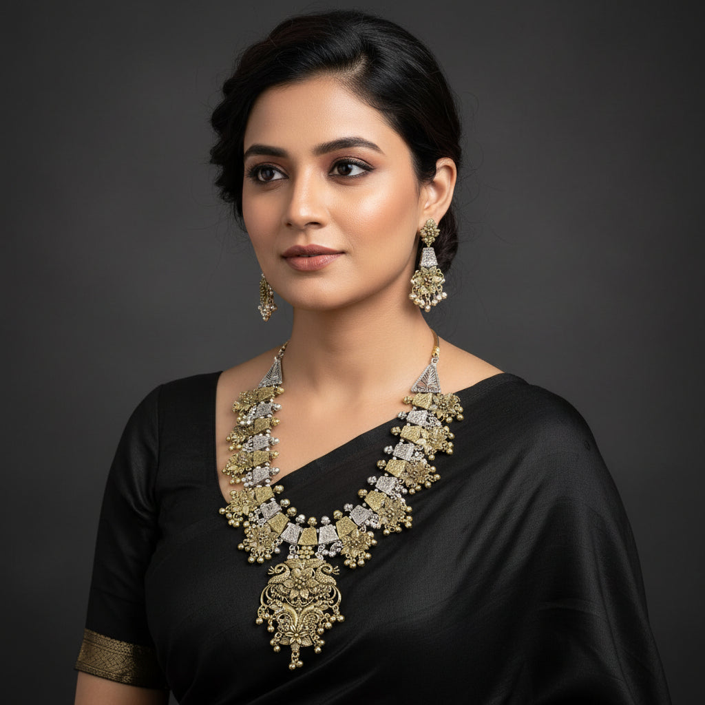 Ornate gold and silver necklace and earrings on a reflective surface