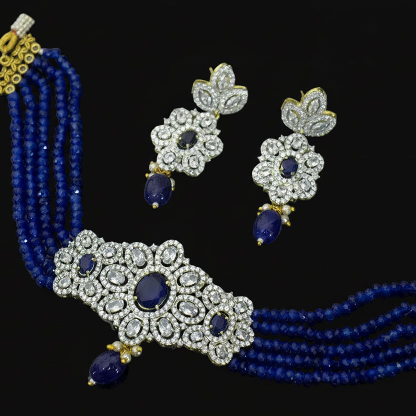 Jewelry set with necklace, earrings, and blue beads on a dark background