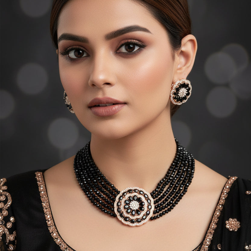 Black beaded necklace with floral designs on a dark background