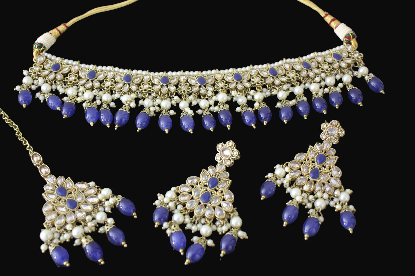 Jewelry set with necklace, earrings, and blue stones on a dark background