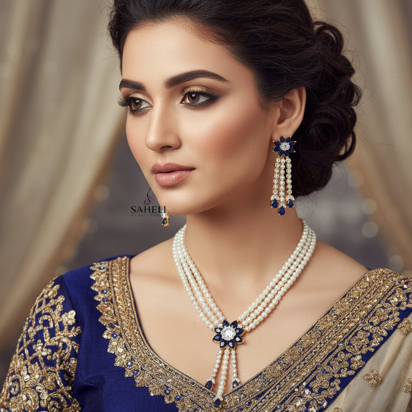 Pearl necklace and earrings with blue gemstones on a dark background, branded 'Saheli'.