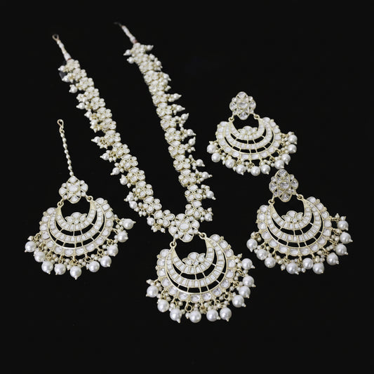 Set of gold and pearl jewelry on a dark background