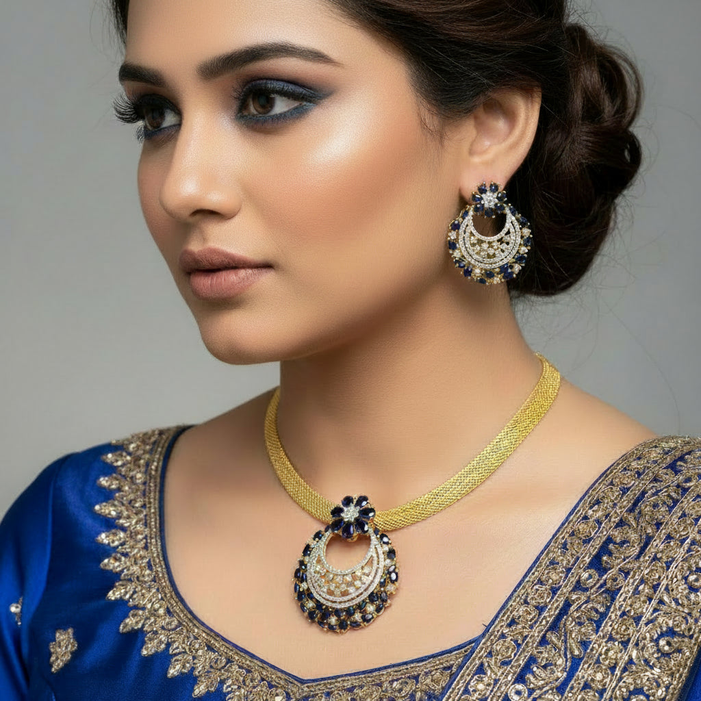 Gold necklace with matching earrings on a dark background, featuring the brand 'Saheli'.