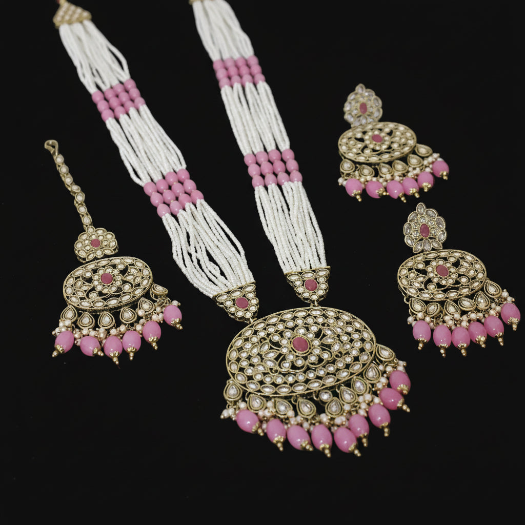 Set of traditional jewelry with pink and white beads on a dark background