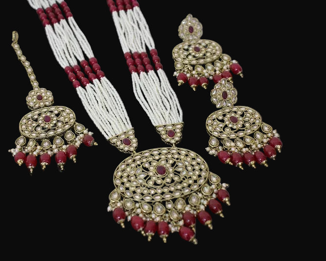 Jewelry set with gold, red, and white elements on a dark background