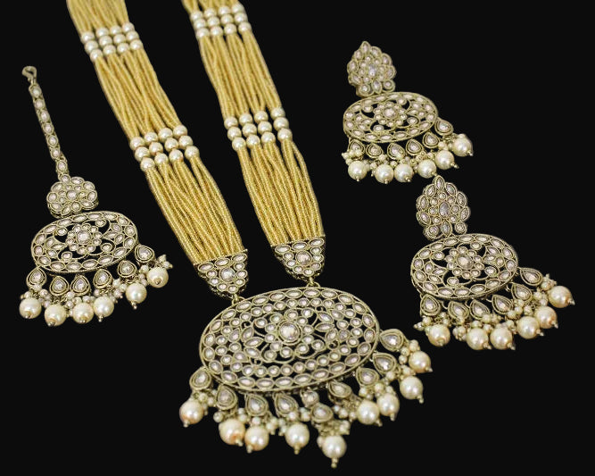 Ornate jewelry set with earrings and a necklace on a dark background