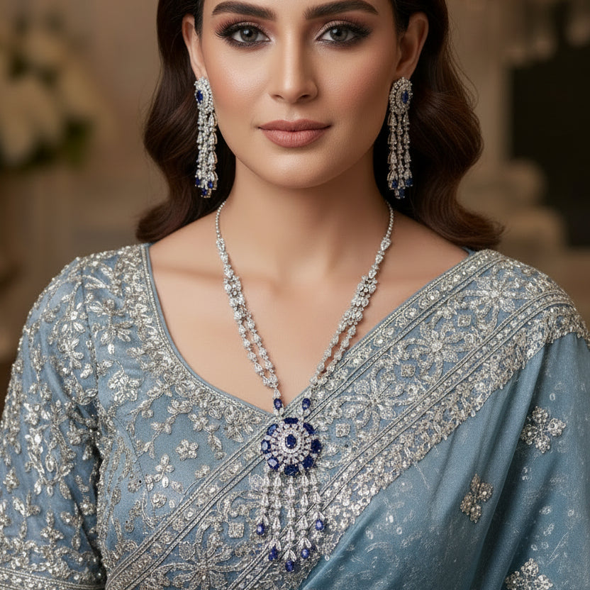 Jewelry set with necklace and earrings featuring blue and clear stones on a black background.