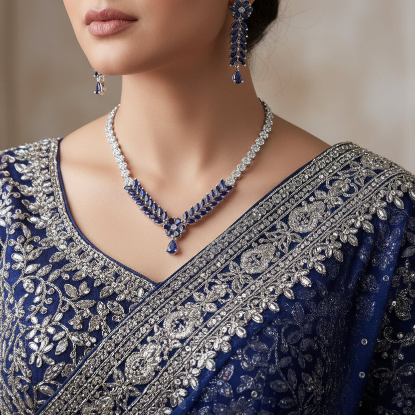 Jewelry set with necklace and earrings featuring blue and clear stones on a dark background