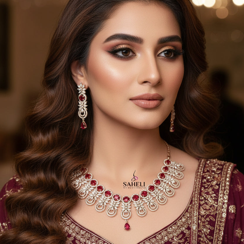 Jewelry set with necklace and earrings featuring red stones on a dark background, branded 'Saheli'.
