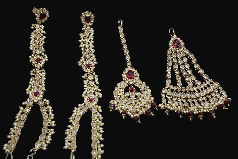Set of gold and red jewelry pieces on a dark background