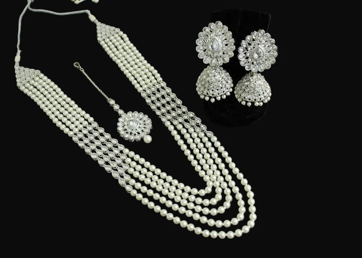 Pearl necklace and earrings set on a dark surface